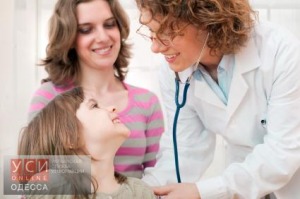 Female mature doctor examining happy child, smiling.