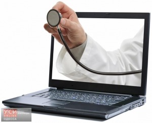 Doctors hand holding a stethoscope through a laptop screen towards a patient