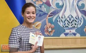 Maria Gaidar, the daughter of Russia's 1990s reformist prime minister Yegor Gaidar, shows her Ukrainian passport after it was handed to her by Ukraine's President Petro Poroshenko, right, in Kiev, Ukraine, Tuesday, Aug. 4, 2015. Gaidar's appointment as deputy governor of Odessa, now led by former Georgian President Mikhail Saakashvili, has been painted as a betrayal in Russia. (AP Photo/Mykhailo Markiv, Pool)